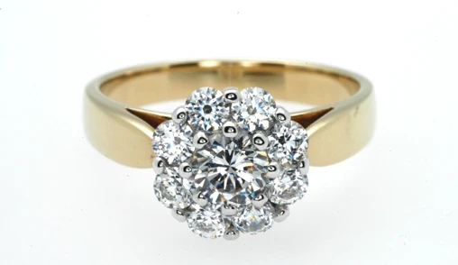 A dazzling two-tone gold ring features a central halo cluster, intricately adorned with sparkling diamonds. 