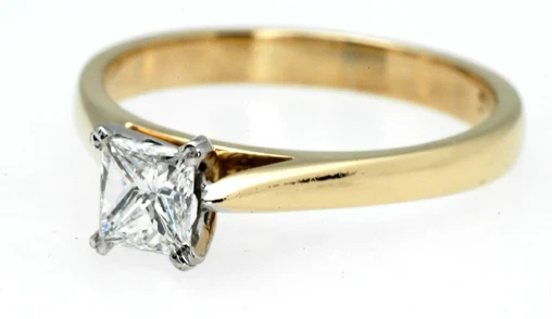 An exquisitely designed princess-cut diamond ring, highlighting the sharp, symmetrical facets of the central diamond.