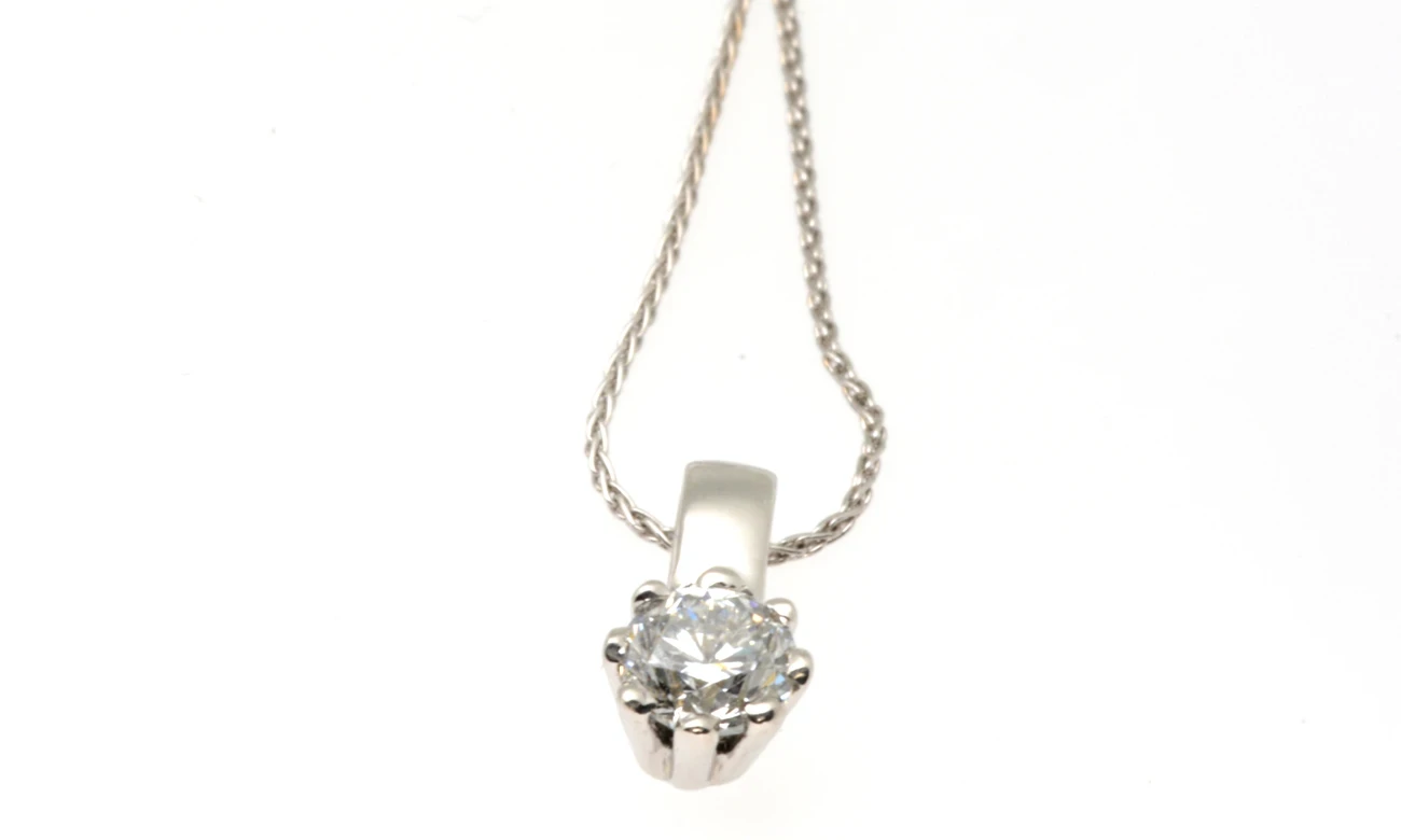 An elegant 0.50-carat diamond pendant featuring a brilliantly cut round diamond set in a classic, finely crafted gold setting.
