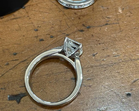 A close-up side view of a stunning 1.70 carat princess-cut diamond ring. 