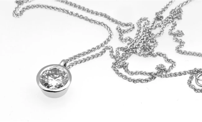  A stunning 1.0-carat diamond pendant elegantly suspended from a delicate platinum chain, reflecting light with unmatched brilliance and clarity. 