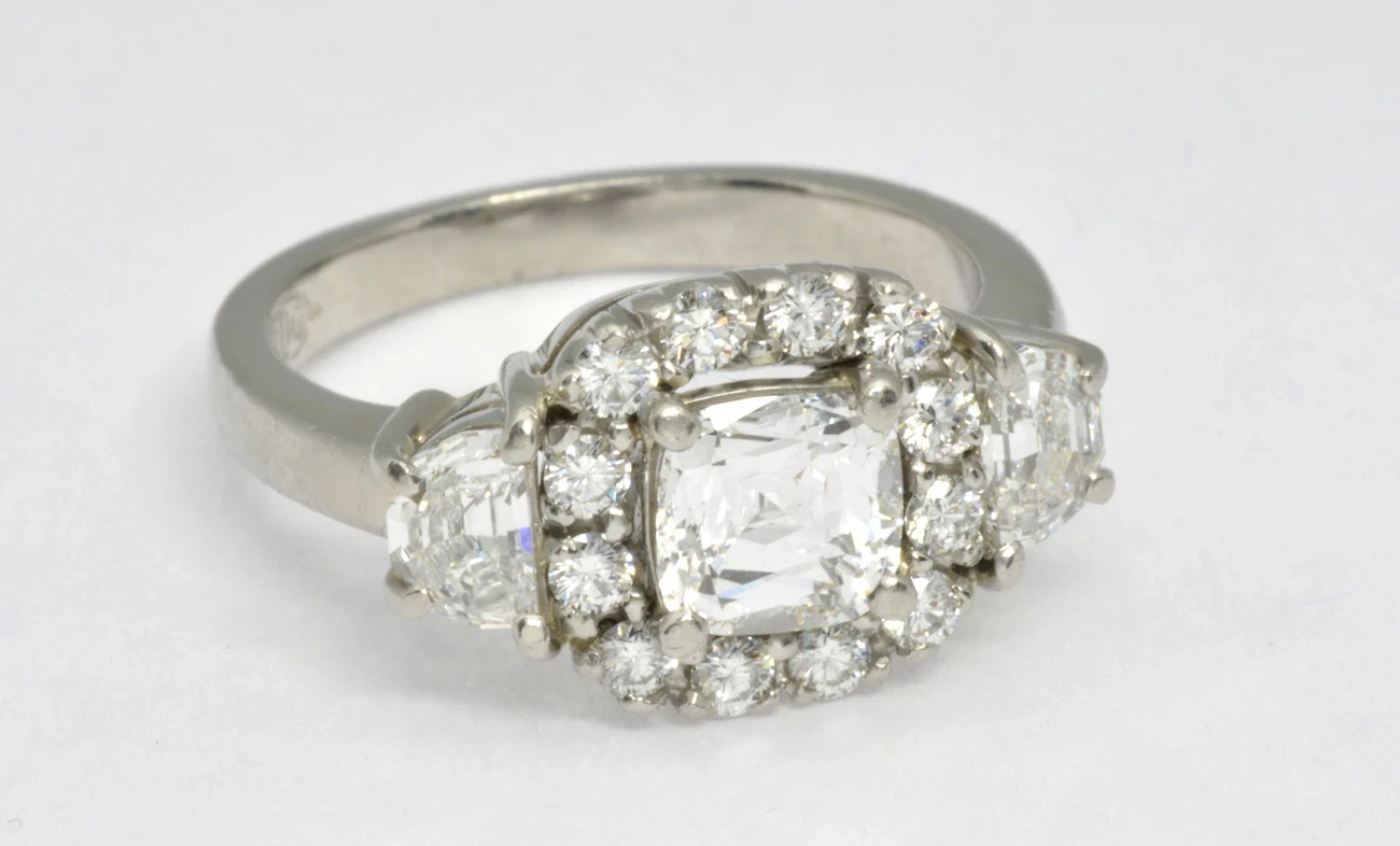 A stunning crisscut diamond engagement ring is displayed against a soft, neutral background.