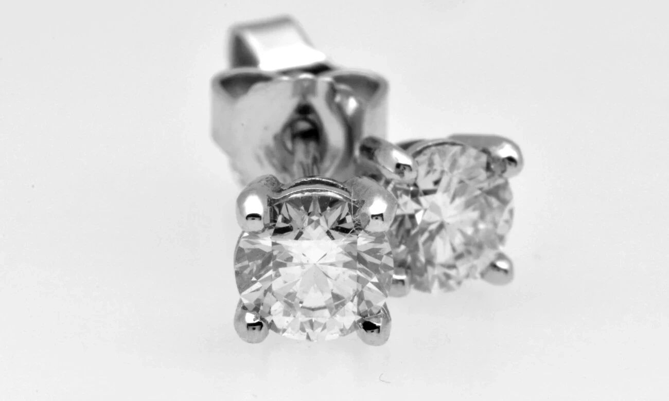 Close-up view of a pair of elegant diamond stud earrings, featuring round brilliant cut diamonds set in a premium white gold setting, showcasing clear sparkle and luxury craftsmanship. Aurum Fine Jewellery, Auckland NZ.