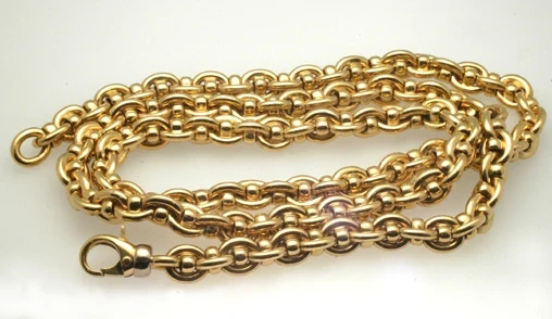 A luxurious, heavy gold chain elegantly displayed on a soft, velvet surface.