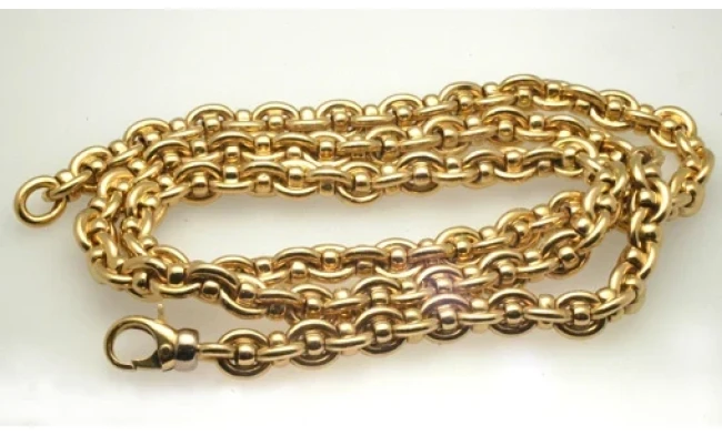 A luxurious, heavy gold chain elegantly displayed on a soft, velvet surface.