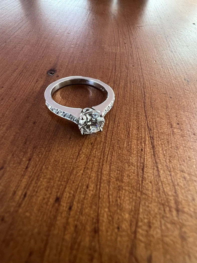 A stunning modern diamond solitaire ring elegantly displayed against a soft, gradient background. 