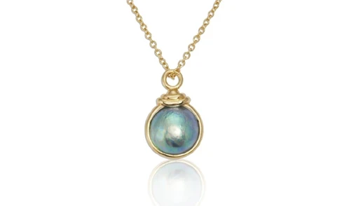 A stunning pendant featuring a lustrous New Zealand Pacific blue pearl suspended delicately on a refined silver chain, showcasing intricate craftsmanship and timeless elegance. Aurum Fine Jewellery, Auckland NZ.