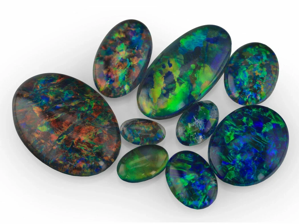 A close-up photograph depicting a pair of opal triplet earrings.