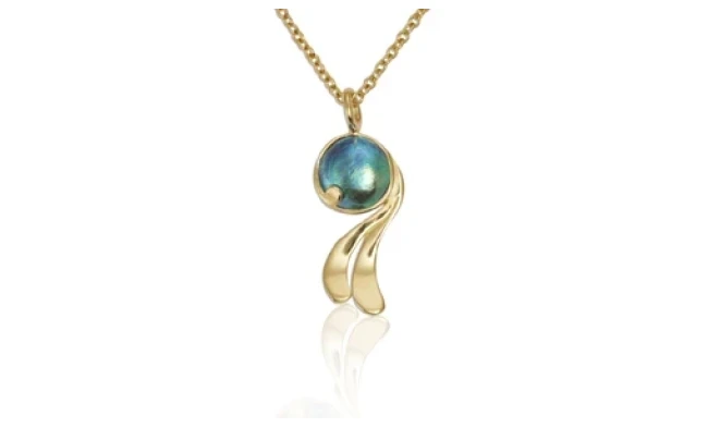 A stunning Pacific blue pearl pendant set in a delicate silver mount, reflecting the subtle hues of the ocean, showcased against a beige background. 