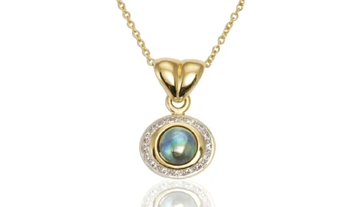 A stunning, elegant pendant featuring a lustrous Pacific pearl, delicately encased in a silver setting, glistening against a neutral background. 