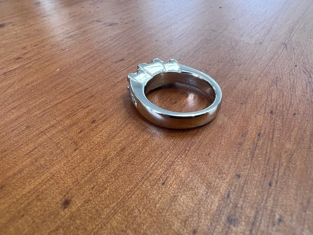 Platinum three stone Princess cut Diamond ring with small square diamonds set into shoulders.