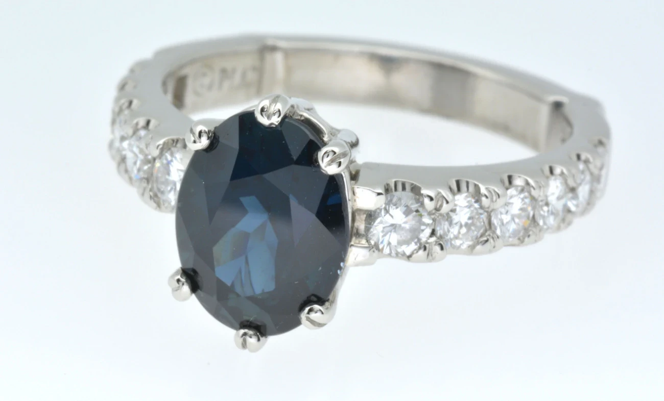An exquisite sapphire and diamond cocktail ring is captured in this high-resolution image, showcasing the luxurious deep blue sapphire encircled by a halo of sparkling white diamonds.